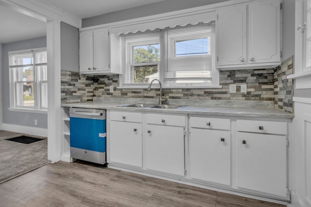 kitchen with white cabinets, dishwasher, sink, and a wealth of natural light