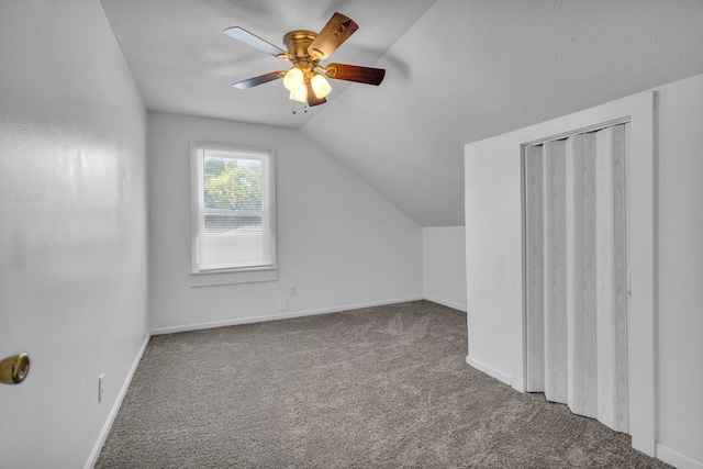 bonus room featuring a textured ceiling, ceiling fan, carpet, and vaulted ceiling