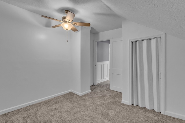 bonus room with light carpet, a textured ceiling, and ceiling fan