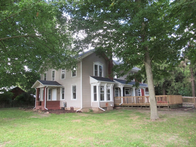 back of house featuring a lawn and a wooden deck