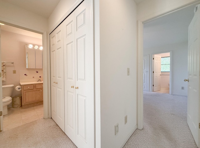 corridor with light colored carpet and sink