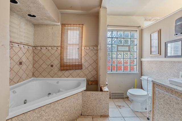 bathroom with tile patterned flooring, a relaxing tiled tub, toilet, and tile walls