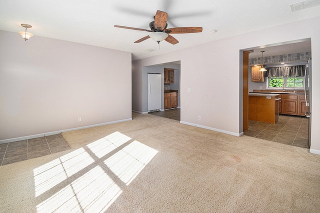 carpeted spare room featuring ceiling fan