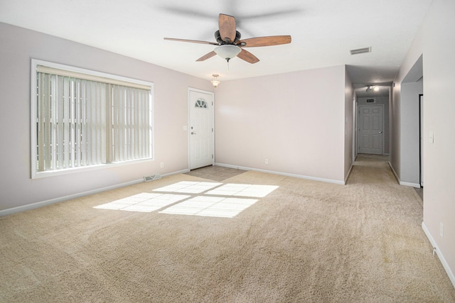 spare room with light colored carpet and ceiling fan