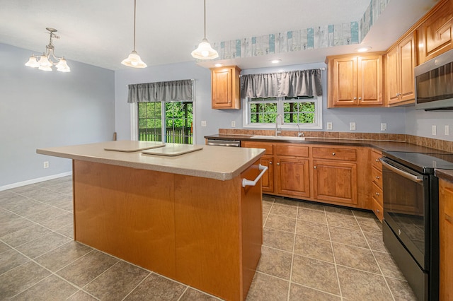 kitchen featuring electric range, a center island, sink, and pendant lighting