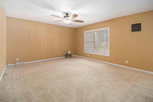 empty room featuring carpet floors and ceiling fan