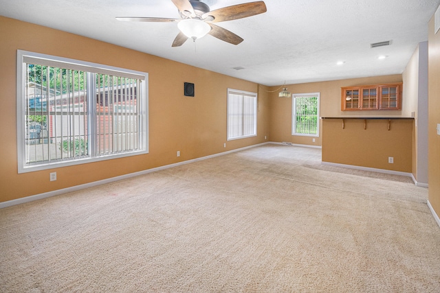 unfurnished living room with ceiling fan and light colored carpet