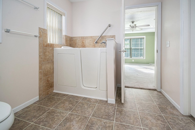 washroom with ceiling fan and dark tile patterned flooring