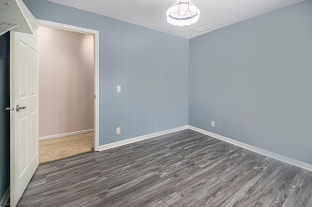 unfurnished room featuring dark wood-type flooring and a textured ceiling