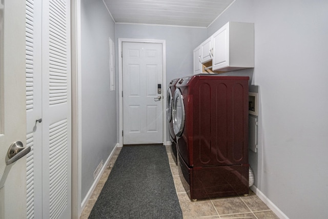 laundry room featuring cabinets, tile patterned floors, and washer and clothes dryer