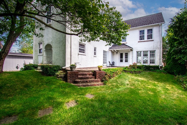 rear view of house with a lawn and french doors