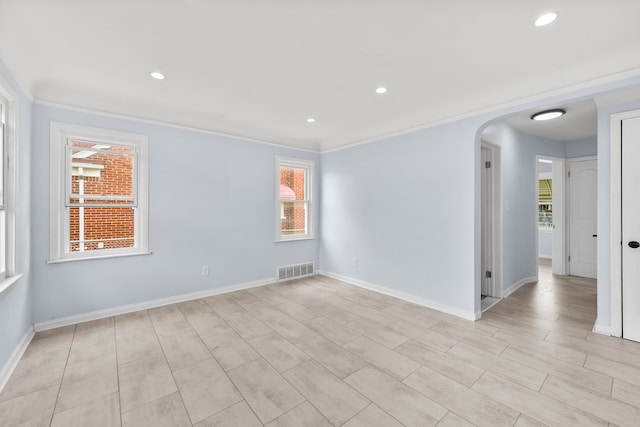 empty room featuring light wood-type flooring and ornamental molding