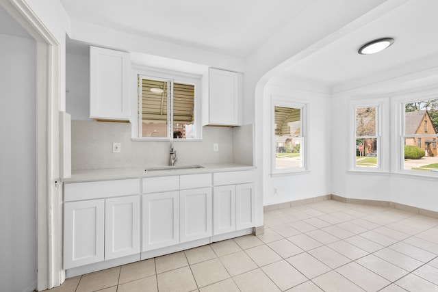 kitchen featuring sink, white cabinets, and light tile patterned flooring