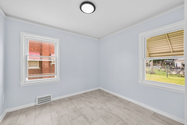 spare room with crown molding and plenty of natural light