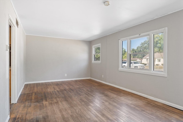 unfurnished room with dark hardwood / wood-style floors and crown molding