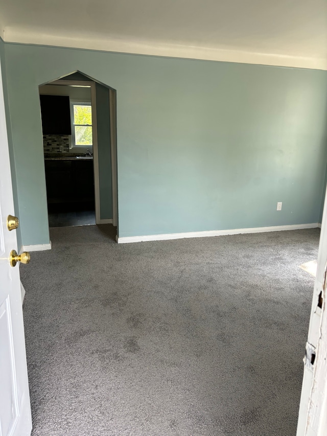 unfurnished room with dark colored carpet