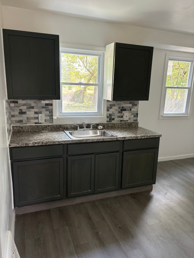 kitchen with dark hardwood / wood-style floors, tasteful backsplash, plenty of natural light, and sink