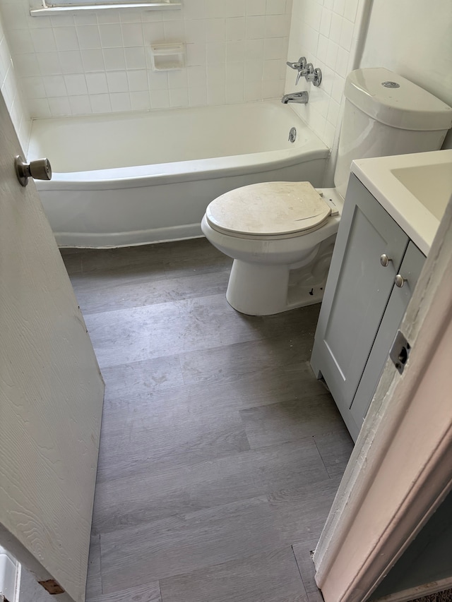 bathroom with hardwood / wood-style floors, vanity, a bathtub, and toilet