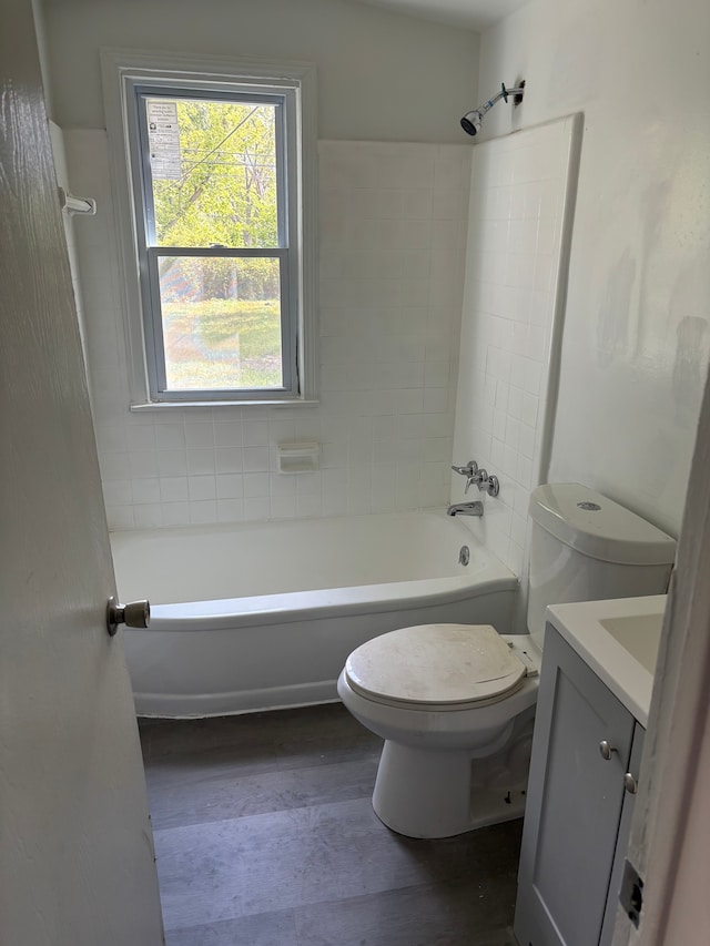 full bathroom featuring tiled shower / bath, hardwood / wood-style floors, vanity, and toilet