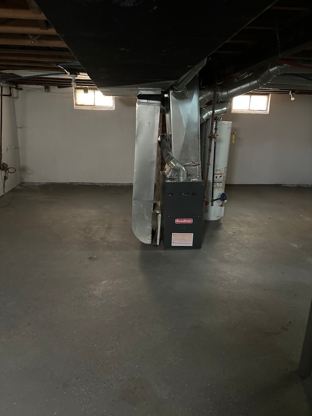 basement with heating unit, a wealth of natural light, and gas water heater