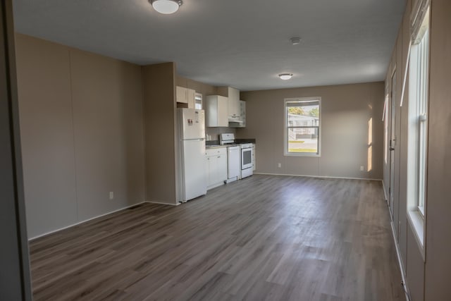 kitchen with white cabinets, white appliances, and hardwood / wood-style flooring