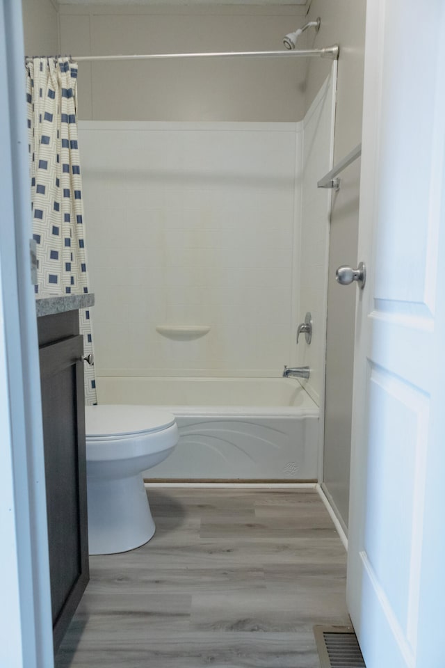 full bathroom featuring hardwood / wood-style floors, vanity, toilet, and shower / bath combo with shower curtain