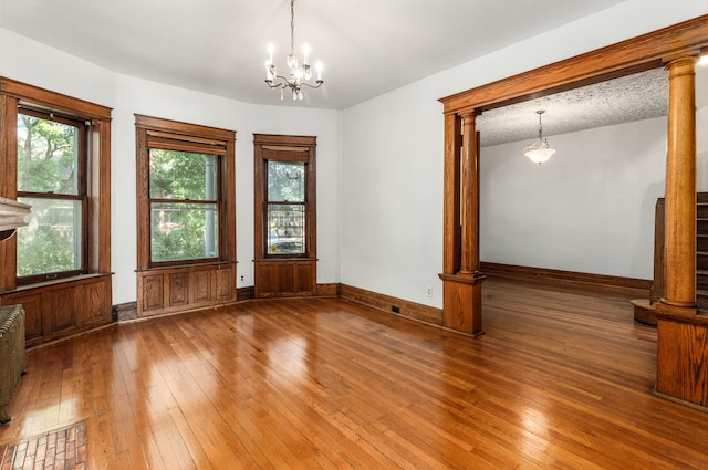 3937 Avery St, Detroit, MI 48208 - unfurnished room with hardwood / wood-style floors, decorative columns, baseboards, and a chandelier