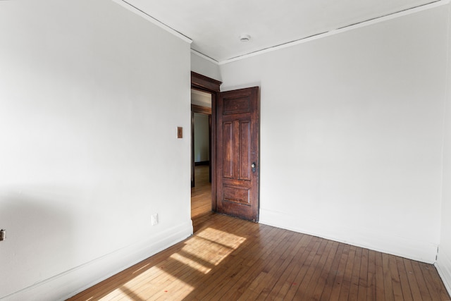 spare room featuring crown molding and dark hardwood / wood-style floors