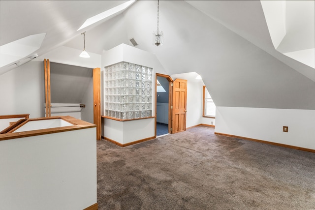 additional living space with lofted ceiling with skylight and carpet floors