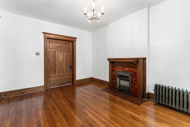 3937 Avery St, Detroit, MI 48208 - unfurnished living room with radiator heating unit, a chandelier, hardwood / wood-style flooring, a fireplace, and baseboards