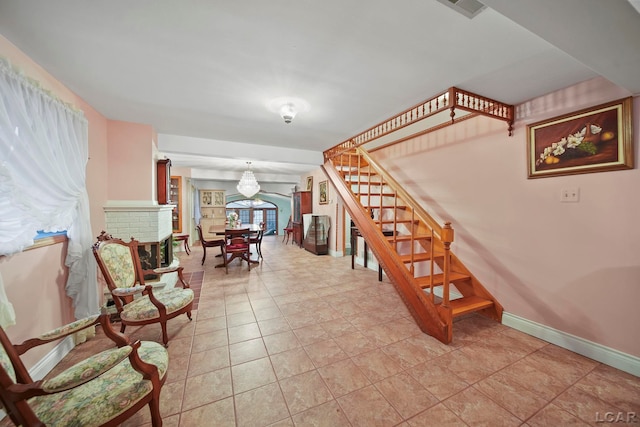 staircase featuring tile patterned floors and an inviting chandelier