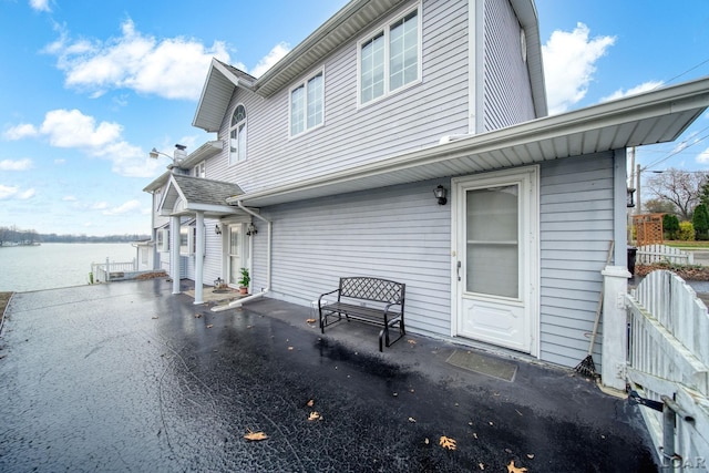 back of property featuring a patio and a water view