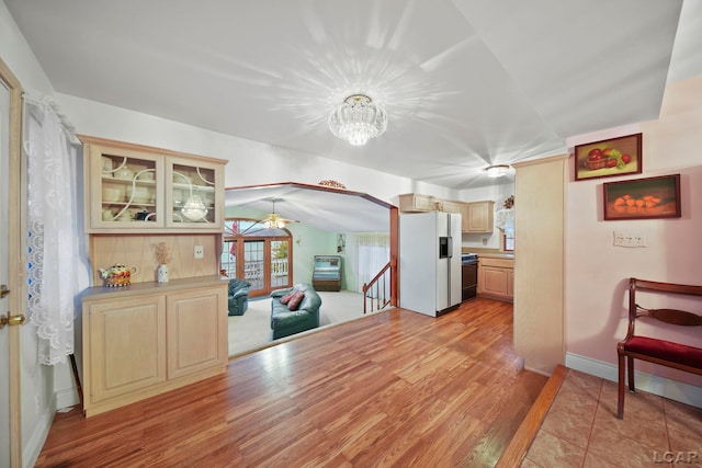 dining room with light wood-type flooring, vaulted ceiling, and a notable chandelier