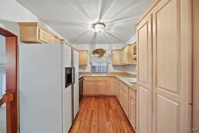 kitchen with light brown cabinets, sink, white refrigerator with ice dispenser, black / electric stove, and light hardwood / wood-style floors