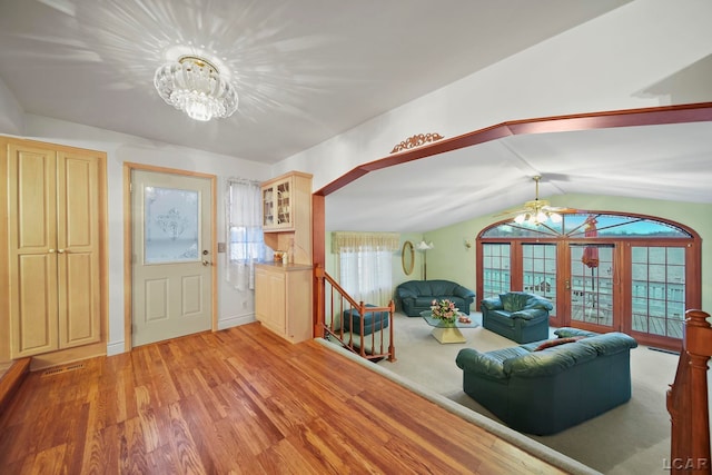 interior space featuring a notable chandelier, light hardwood / wood-style floors, lofted ceiling, and a wealth of natural light