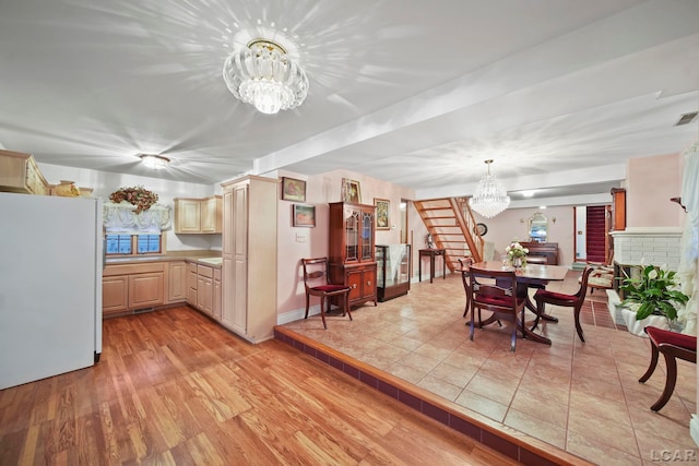 dining space featuring a fireplace, light hardwood / wood-style flooring, and a chandelier