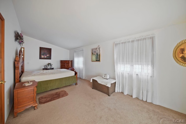 carpeted bedroom with lofted ceiling