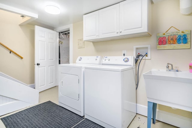 laundry area featuring cabinets, sink, and washing machine and clothes dryer