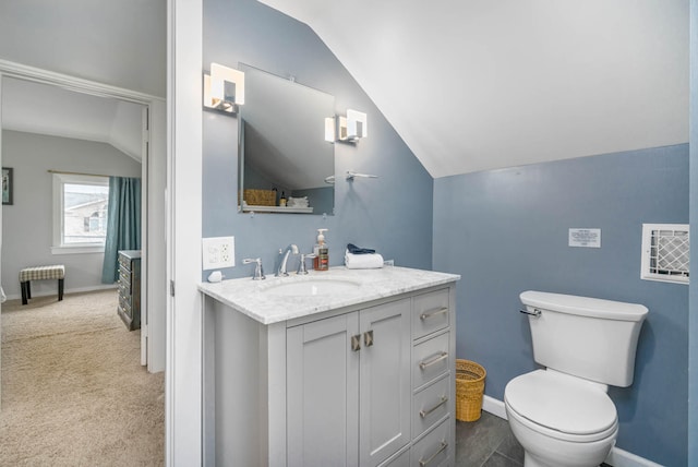 bathroom with vanity, vaulted ceiling, and toilet