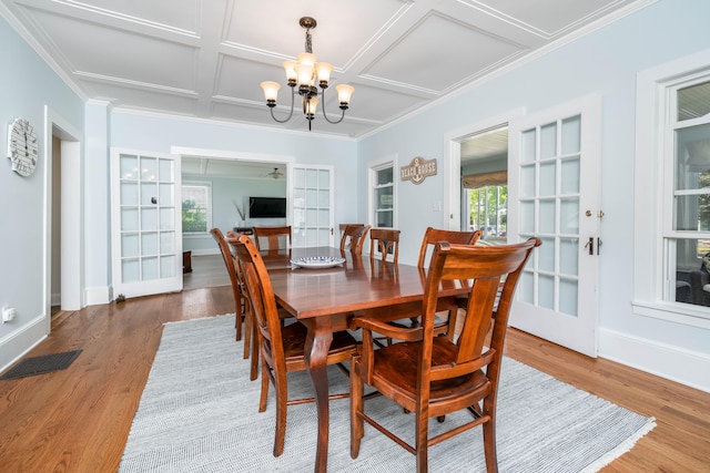 dining space with a chandelier, hardwood / wood-style flooring, plenty of natural light, and coffered ceiling