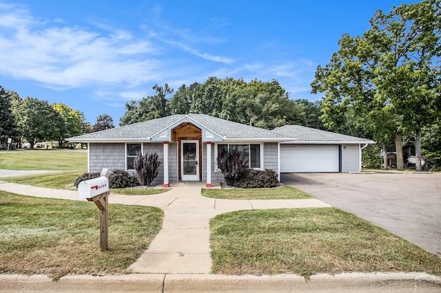 ranch-style house featuring a garage and a front lawn