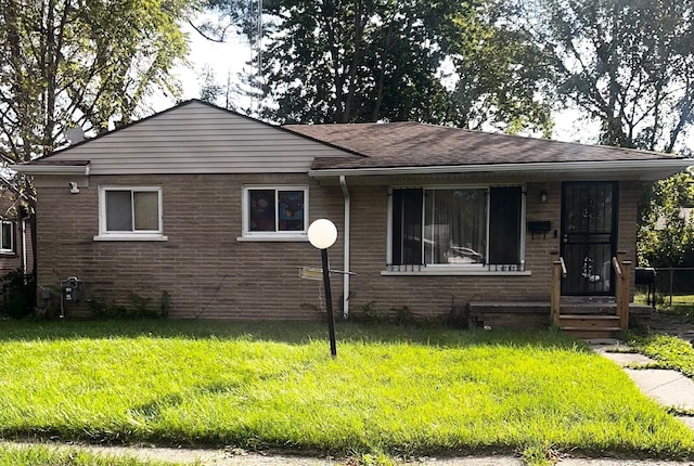 6702 Cranwood Dr, Flint, MI 48505 - bungalow-style home featuring roof with shingles, a front yard, and brick siding