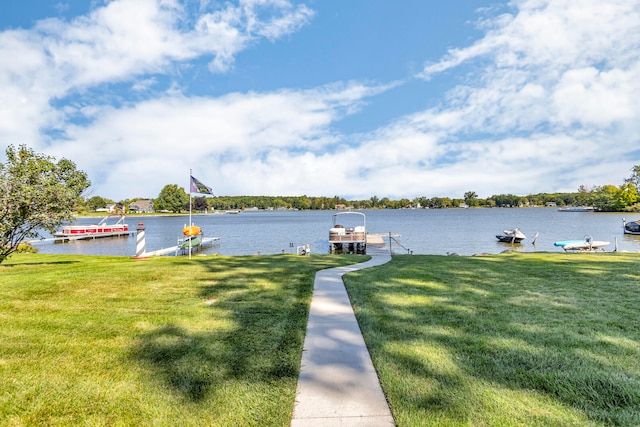 dock area with a lawn and a water view