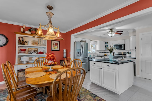 dining space with ceiling fan with notable chandelier, light tile patterned flooring, ornamental molding, and sink