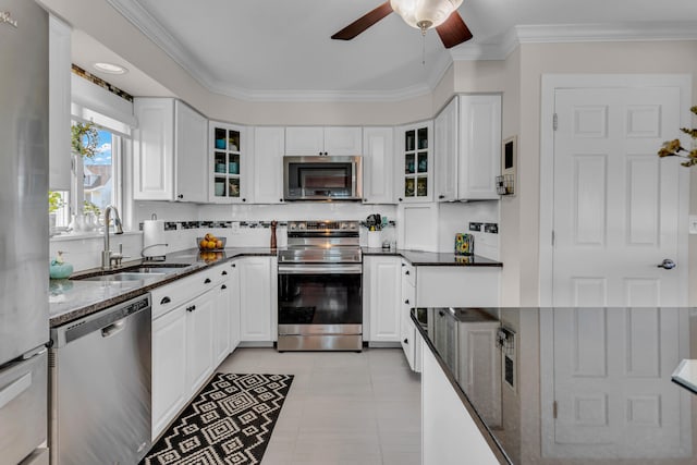 kitchen featuring crown molding, sink, dark stone countertops, appliances with stainless steel finishes, and white cabinetry