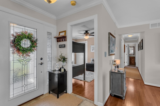 entryway with ceiling fan, ornamental molding, and light hardwood / wood-style flooring