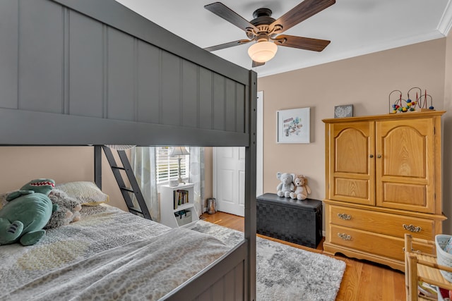 bedroom featuring light wood-type flooring, ceiling fan, and ornamental molding