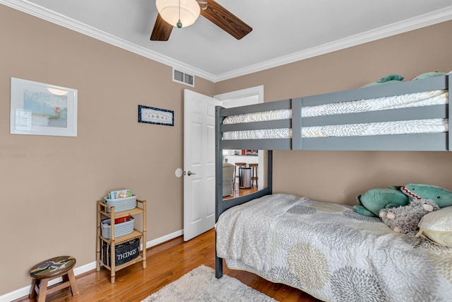 bedroom with hardwood / wood-style flooring, ceiling fan, and ornamental molding