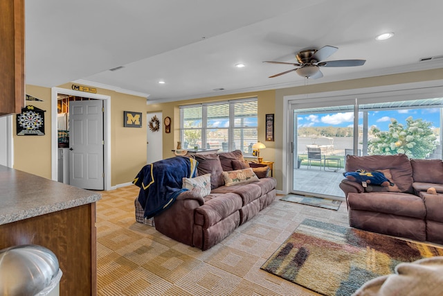 carpeted living room with ceiling fan and crown molding