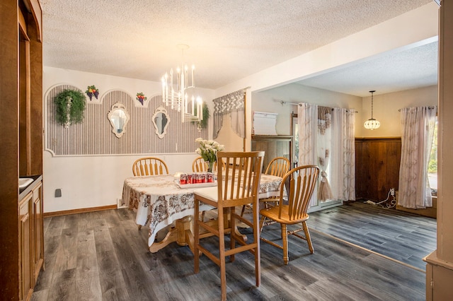 dining room featuring dark hardwood / wood-style floors, wood walls, a textured ceiling, and a chandelier